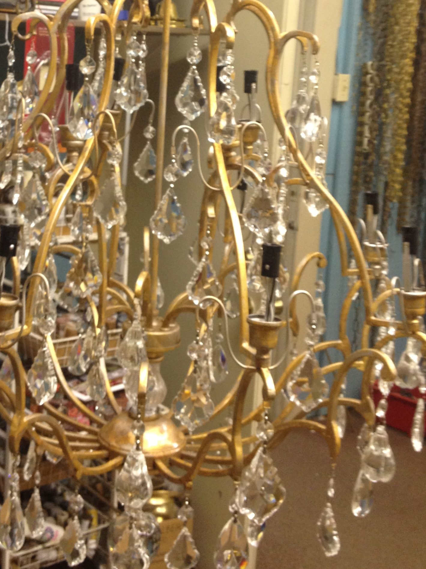 Bronze chandelier refinished to a brilliant gold finish with crystal rehung. 